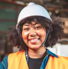 Smiling technician in a white hard hat and safety vest